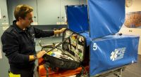 Auf dem Oktoberfest 2024 ist man für alle Notfälle gewappnet: Einsatzleiter Maximilian Pfandl vom Sanitätsdienst mit einer Transporttrage mit Sichtschutz für den Patiententransport über das Festgelände.