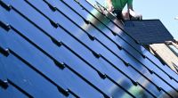 Neuartige Solar-Module: Handwerker arbeiten an einem Photovoltaik Dach