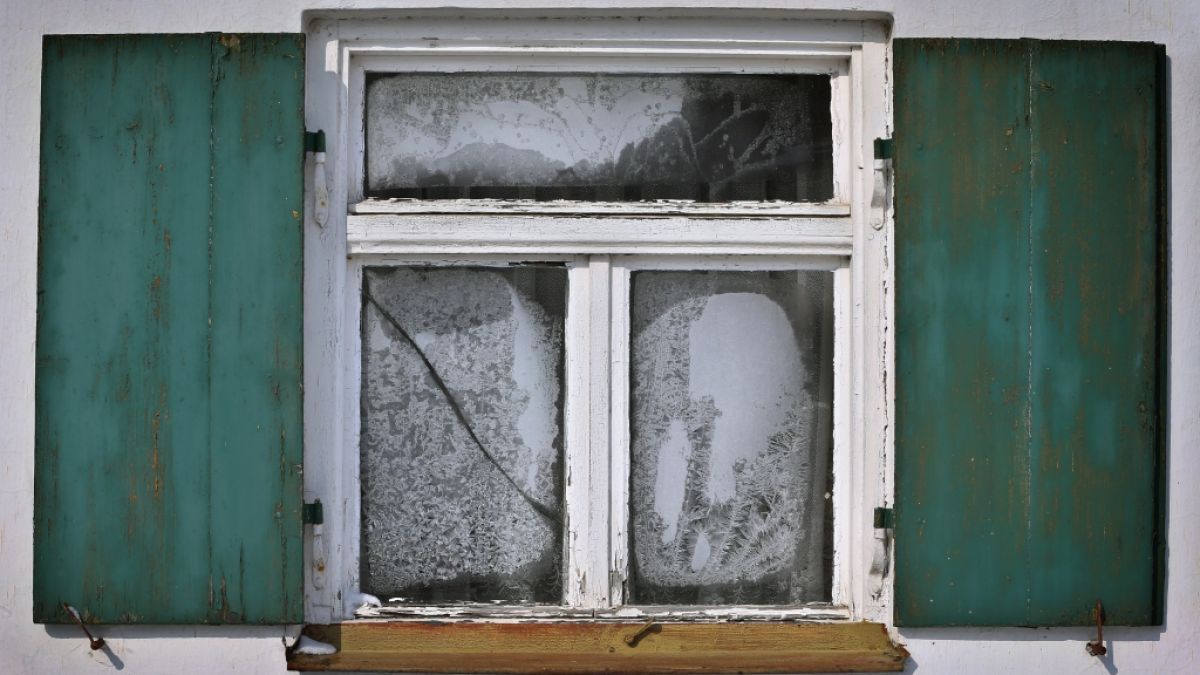 Eisblumen bilden sich an einem alten Fenster. (Symbolbild) (Foto)