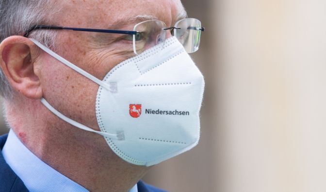 Stephan Weil, Ministerpräsident von Niedersachsen, steht mit einer FFP2-Maske mit dem Schriftzug 