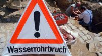 Nach Rohrbruch: Zwei Männer arbeiten an einem defekten Rohr (Archivbild).