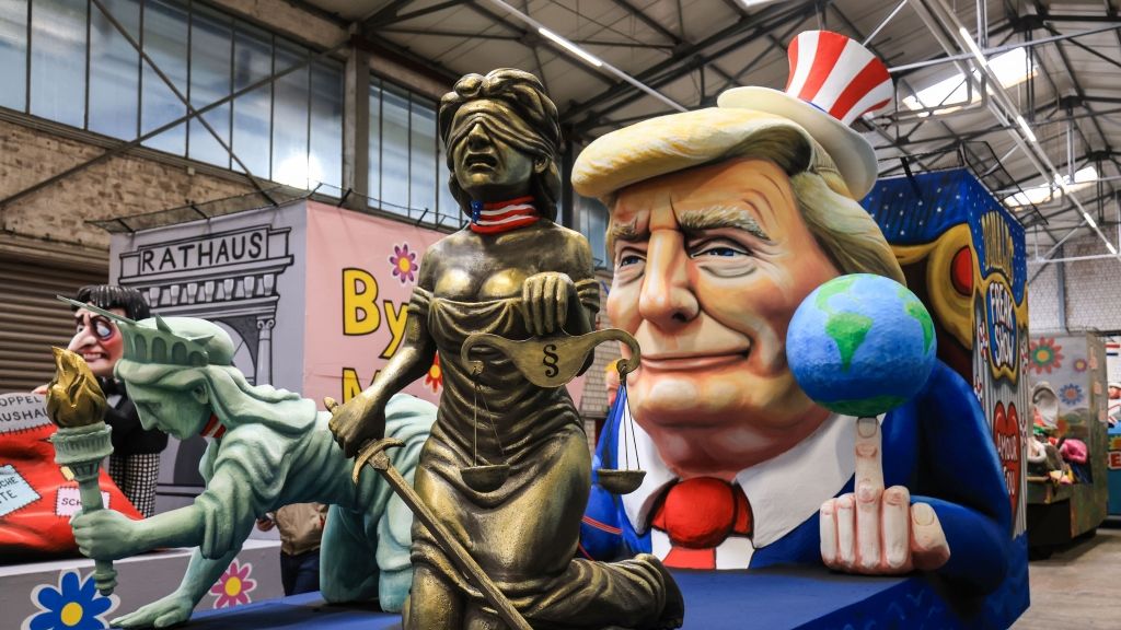 US-Präsident Donald Trump hält auf seinem ausgestreckten Mittelfinger eine Erdkugel. Mit dem Motivwagen in Köln werden auf umstrittene außen- sowie innenpolitische Entscheidungen des Republikaner angespielt. (Foto)