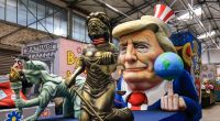 US-Präsident Donald Trump hält auf seinem ausgestreckten Mittelfinger eine Erdkugel. Mit dem Motivwagen in Köln werden auf umstrittene außen- sowie innenpolitische Entscheidungen des Republikaner angespielt.