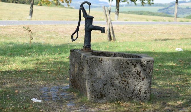 Der Brunnen im eigenen Garten kann auch klassisch mit Muskelkraft betrieben werden – darf aber auch modern sein.