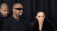 Kanye West und Bianca Censori lächeln.