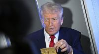 Donald Trump zeigt an Bord der Air Force One die goldene 5-Millionen-Dollar-Karte.
