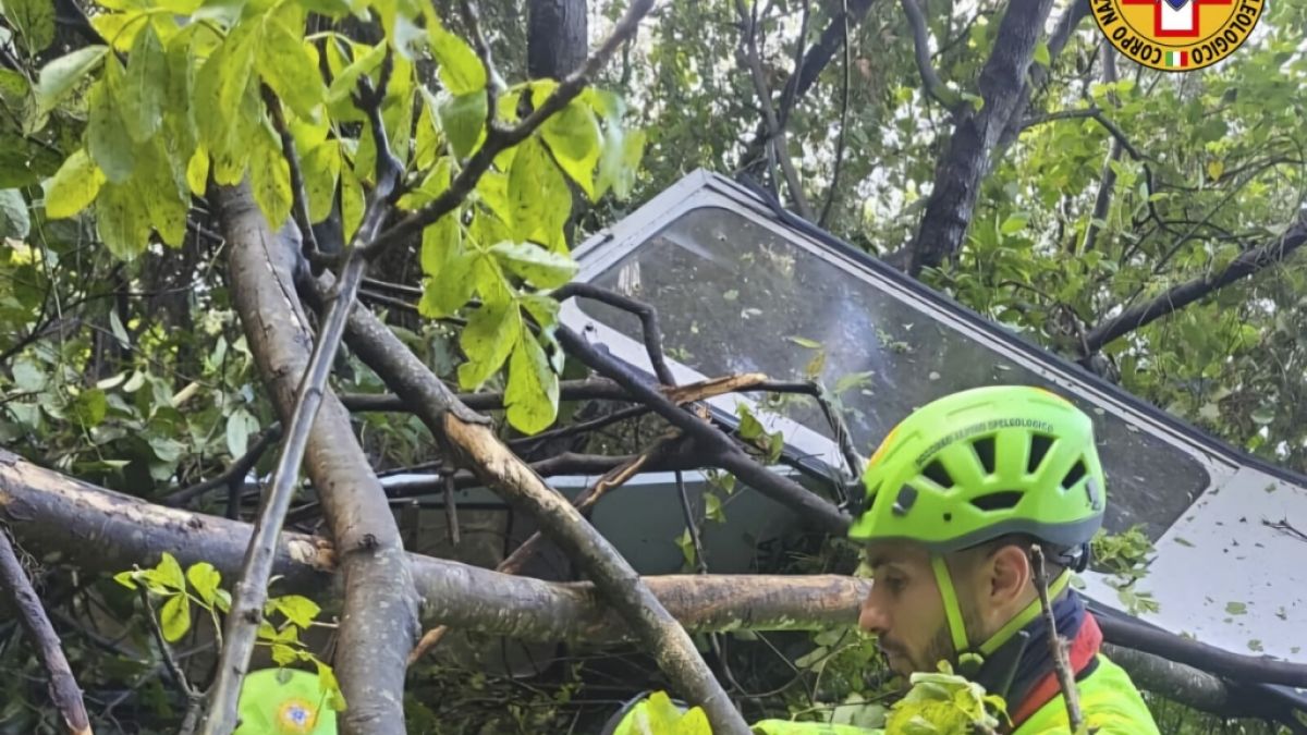 Retter stehen an der zertrümmerten Seilbahn-Gondel, die am Berg Faito bei Neapel abgestürzt ist. Vier Menschen starben bei dem Unglück. Retter stehen an der zertrümmerten Seilbahn-Gondel, die am Berg Faito bei Neapel abgestürzt ist. Vier Menschen starben bei dem Unglück. (Foto)