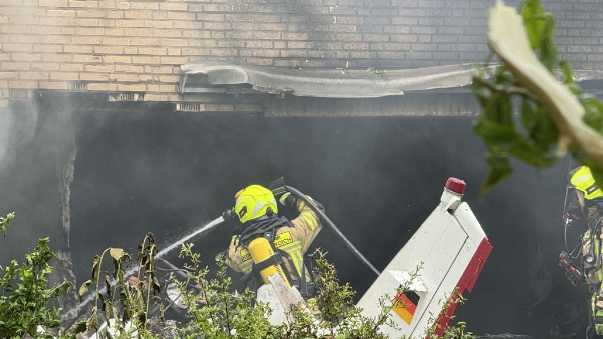 Die Feuerwehr arbeitet an der Absturzstelle, nachdem ein Flugzeug in ein Wohnhaus gestürzt ist. (Foto)