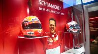 Ein Foto von Michael Schumacher neben seinen Rennfahrer-Helmen ausgestellt in der Ausstellung 