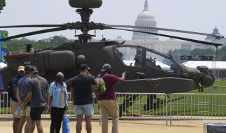 Menschen blicken auf einen Militärhubschrauber während der Vorbereitungen für die bevorstehende Militärparade. Menschen blicken auf einen Militärhubschrauber während der Vorbereitungen für die bevorstehende Militärparade.