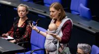 Hanna Steinmüller (Grüne), Mitglied des Deutschen Bundestages, spricht bei der Sitzung des Bundestags mit ihrem Kind am Bauch.