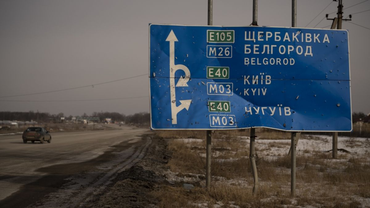 Ein Auto fährt an einem von Kugeln und Granatsplittern beschädigten Straßenschild auf der Straße zur russischen Stadt Belgorod vorbei. (Foto)