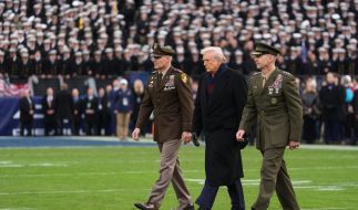 US-Präsident Donald Trump wird auf das Spielfeld eskortiert, um am feierlichen Münzwurf vor dem Beginn des NCAA-College-Footballspiels zwischen Army und Navy im MT Bank Stadium teilzunehmen.