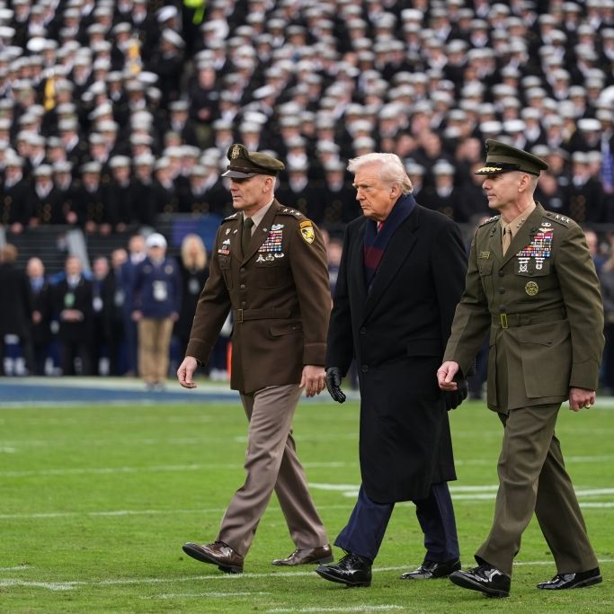 US-Präsident Donald Trump wird auf das Spielfeld eskortiert, um am feierlichen Münzwurf vor dem Beginn des NCAA-College-Footballspiels zwischen Army und Navy im MT Bank Stadium teilzunehmen.
