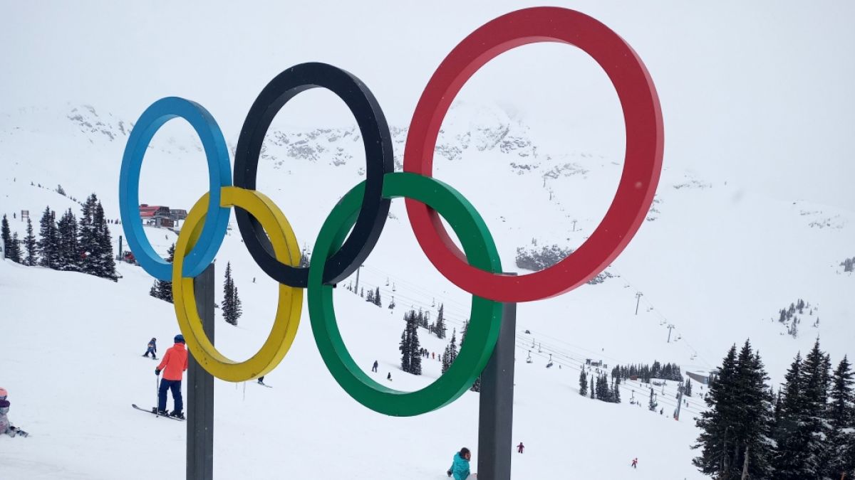 Die Olympischen Ringe vor einer Skipiste. (Foto)