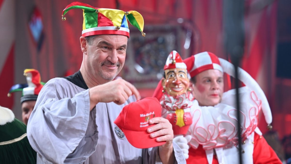 Der bayerische Ministerpr&auml;sident Markus S&ouml;der (CSU) zeigt, nachdem er die Laufnarren-Kappe bekommen hat, sein Basecap mit der Aufschrift "Make Bayern great again". (Foto)