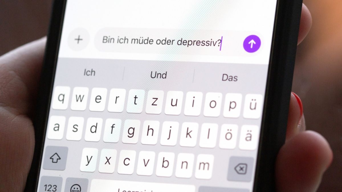 Eine Person h&auml;lt ein Smartphone in der Hand, auf dem eine Suchanfrage mit der Frage &laquo;Bin ich m&uuml;de oder depressiv?&raquo; in einem KI-Chatfenster zu sehen ist. (Symbolbild) (Foto)