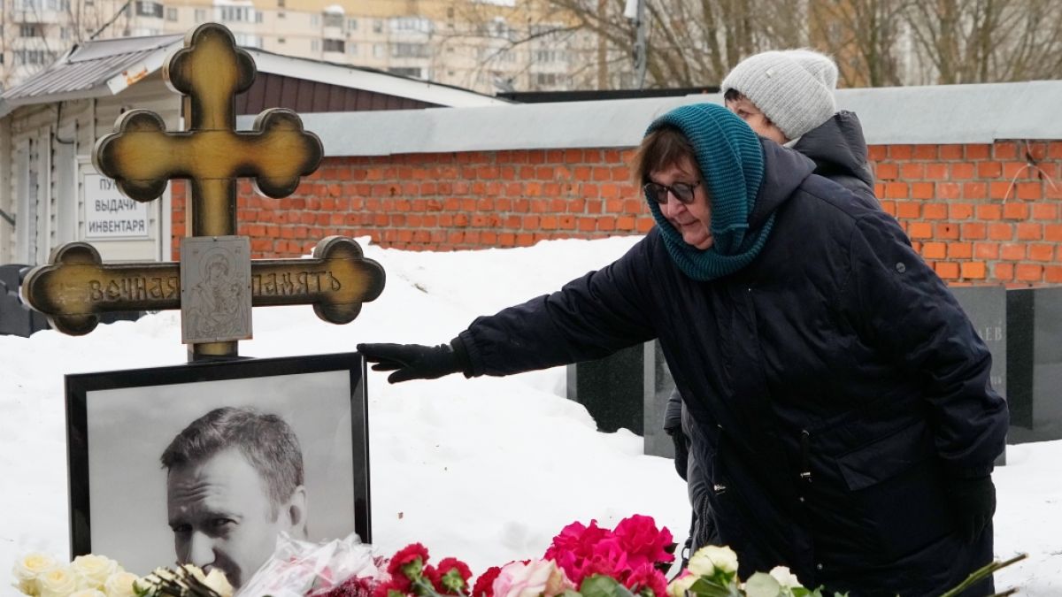 Die Mutter des verstorbenen russischen Oppositionsf&uuml;hrers Alexej Nawalny, Ljudmila Nawalnaja, ber&uuml;hrt zwei Jahre nach seinem Tod sein Portr&auml;t an seinem Grab auf dem Borisowskoje-Friedhof. (Foto)