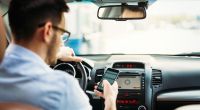 Wer sein Smartphone im Auto unbedingt nutzen will, sollte lieber auf Sprachsteuerung setzen, statt es in die Hand zu nehmen.