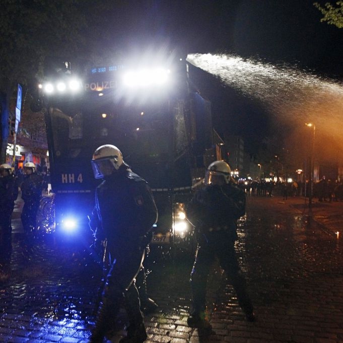 Polizisten mit einem Wasserwerfer riegeln am 1. Mai im Schanzenviertel in Hamburg die Straße vor der 