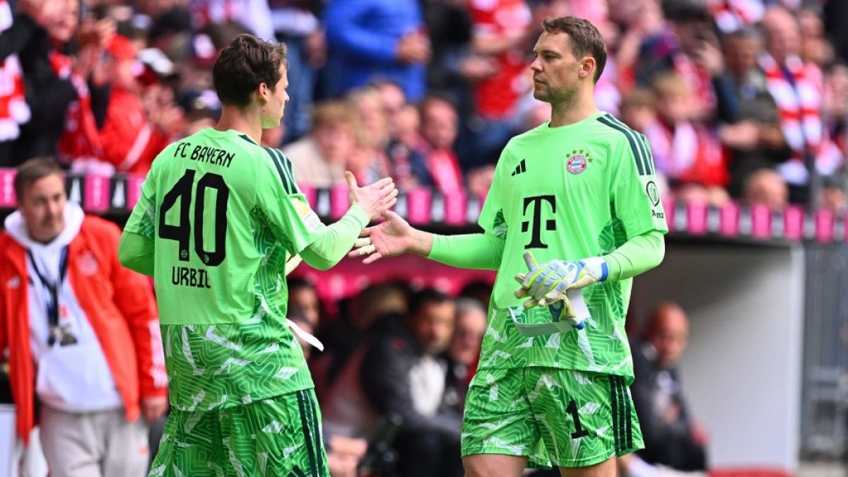 Manuel Neuer klatscht bei der Auswechslung mit Jonas Urbig ab. (Foto)