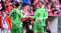 Manuel Neuer klatscht bei der Auswechslung mit Jonas Urbig ab.