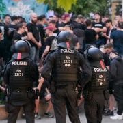 Einsatzkräfte der Polizei bewachen eine Gruppe Fußballfans in der Leipziger Innenstadt.