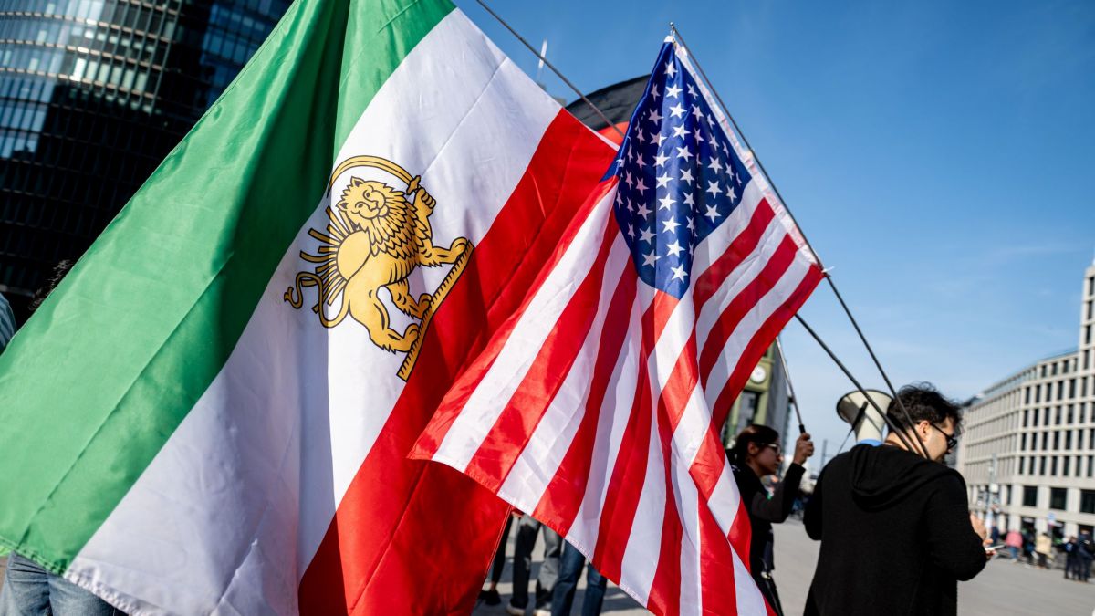 Menschen schwenken bei einer Iran-Demonstration eine historische iranische und eine US-Fahne auf dem Potsdamer Platz. (Foto)