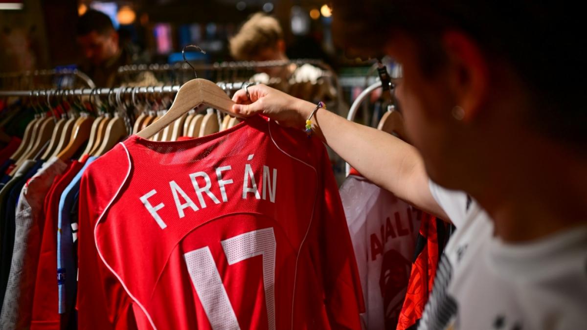 Ein Fan schaut sich w&auml;hrend eines Markts f&uuml;r Fu&szlig;ball-Retro-Trikots ein Trikot von Farf&aacute;n an. (Foto)