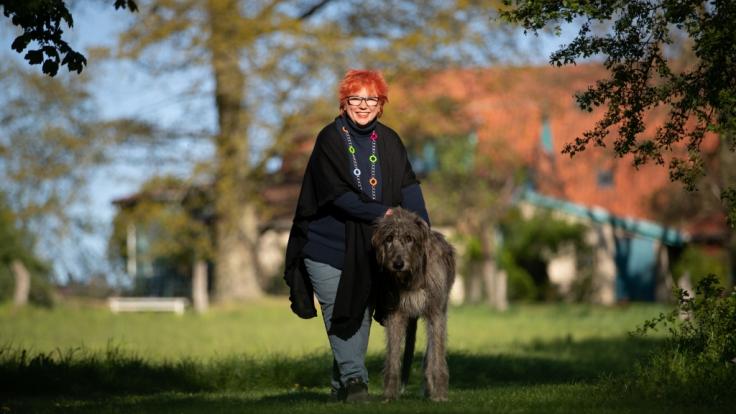 Barbara Salesch steht mit ihrem Hund Piri im Garten ihres Hauses in Petershagen.