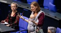 Hanna Steinmüller (Grüne), Mitglied des Deutschen Bundestages, spricht bei der Sitzung des Bundestags mit ihrem Kind am Bauch.