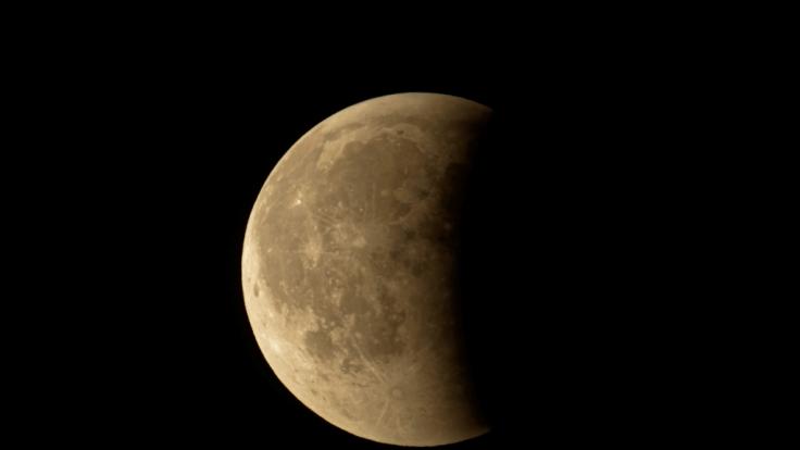 Eine partielle Mondfinsternis färbt den Donnermond rostrot.