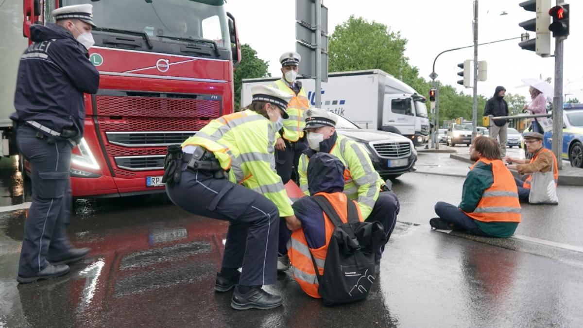 Polizisten tragen einen Demonstranten der Aktivistengruppierung "Letzte Generation" weg, der eine Hauptverkehrsstra&szlig;e in Stuttgart blockiert hat. (Foto)