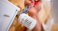 Heizungsausfall im Winter vorbeugen: Ein Handwerker arbeitet an einem Heizkörper
