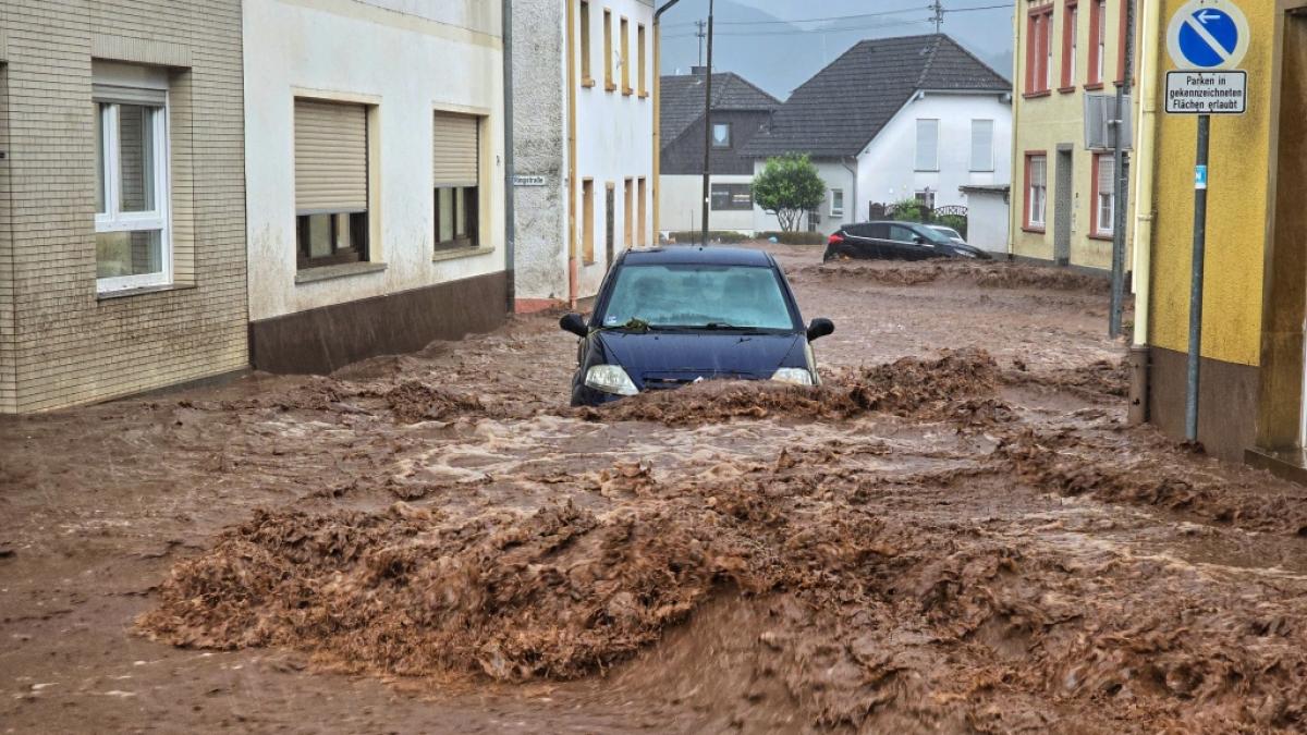 Ein Auto bahnt sich den Weg durch die Wassermassen. Extremer Starkregen hat am Pfingstsonntag in der rheinland-pf&auml;lzischen Stadt Kirn zu &Uuml;berflutungen und Erdrutschen gef&uuml;hrt. (Foto)