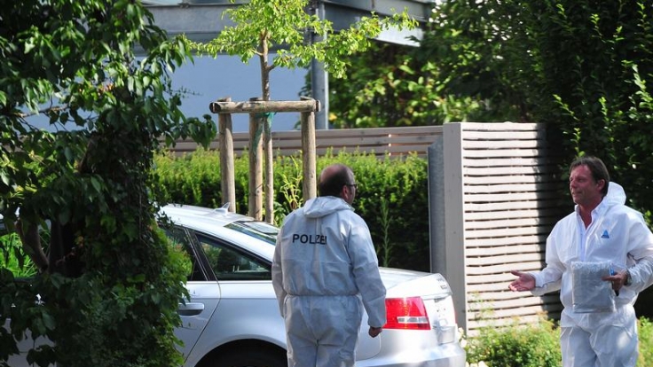 Kriminalbeamte in weißen Overalls sichern am Auto von Thomas Bögerl Spuren.