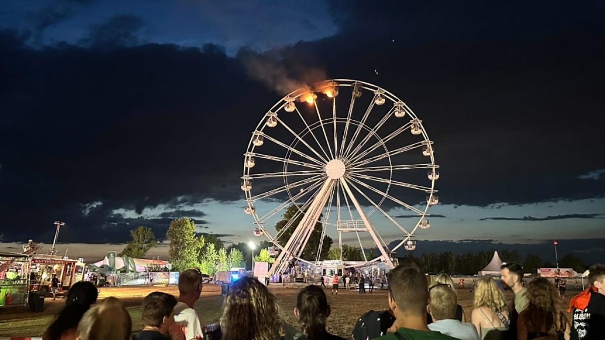 Besucher des Highfield-Festivals blicken entsetzt auf das brennende Riesenrad. (Foto)