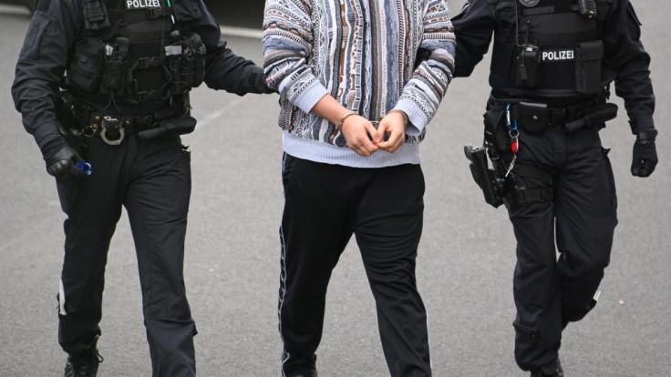 Ein verdächtiger Mann (M) im Fall um den Kunstdiebstahl im Grünen Gewölbe wird von Polizisten in das Gebäude des Oberlandesgerichts Dresden geführt.