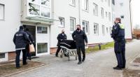 Bestatter transportieren im Stadtteil Bramfeld einen Sarg aus einem Mehrfamilienhaus ab.