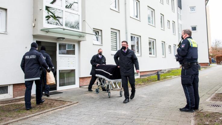 Bestatter transportieren im Stadtteil Bramfeld einen Sarg aus einem Mehrfamilienhaus ab.