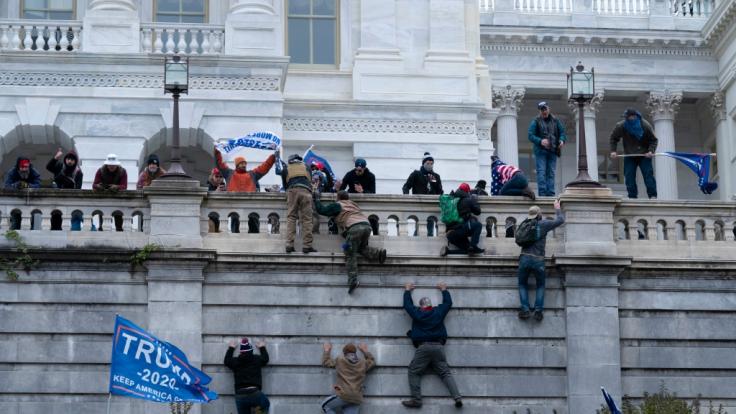 Anhänger von Präsident Donald Trump klettern in Washington auf die Westwand des US-Kapitols.