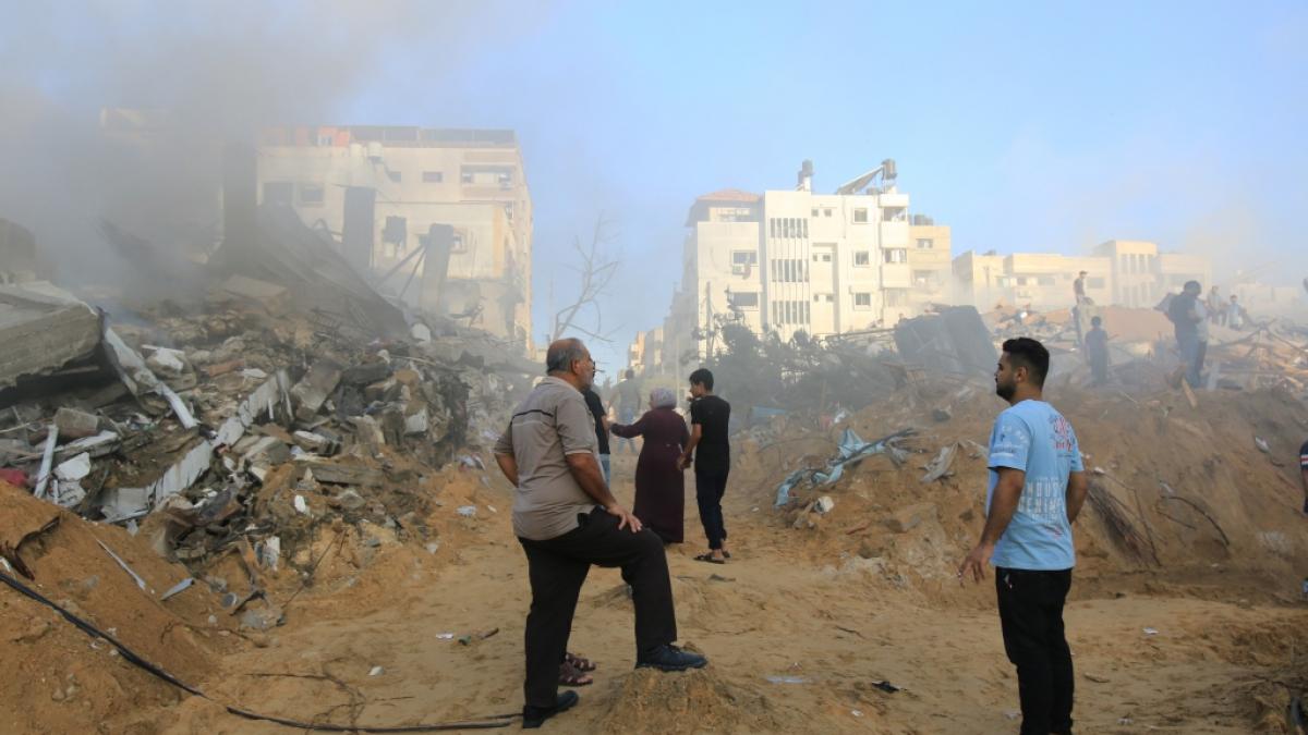 Menschen stehen nach israelischen Angriffen vor Tr&uuml;mmerhaufen, w&auml;hrend pal&auml;stinensische Zivilschutzteams und Zivilisten versuchen, Menschen unter den Tr&uuml;mmern zu retten. (Foto)