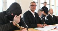 Der 19-jähriger Angeklagte (l) zeigt im Gerichtssaal im Landgericht den Mittelfinger.