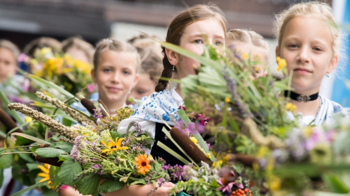 In Tracht gekleidete M&auml;dchen tragen zu Maria Himmelfahrt in Kochel am See (Bayern) Kr&auml;uterbuschen in die Kirche. Allj&auml;hrlich findet am 15. August der gro&szlig;e Kocheler Heimattag statt. (Foto)