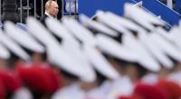 Ein Putin-Soldat posiert mit einem menschlichen Schädel auf einer Bühne.