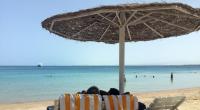 Eine Frau und ein Mann entspannen in Liegestühlen unter einem Sonnenschirm an einem öffentlichen Strand im ägyptischen Hurghada. Vor wenigen Tagen wurden in dem beliebten Urlaubsort zwei tote Hotelgäste aufgefunden.