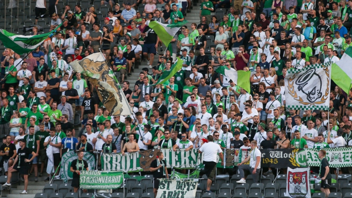 Mit Fahnen und Jubel feuern die Fans des VfL Wolfsburg ihren Verein an. (Symbolbild) (Foto)