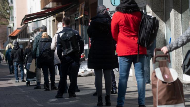 Seit Erlass der neuen Ausgangsbeschränkungen bilden sich teilweise lange Schlangen vor den Supermärkten.