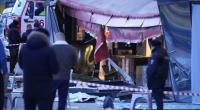 Russische Ermittler und Polizisten stehen am Tatort nach einer Explosion in einem Café.