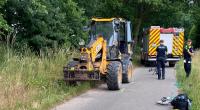 Polizeibeamte stehen neben einem Bagger nach einem Unfall auf einem Feldweg in Toppenstedt.